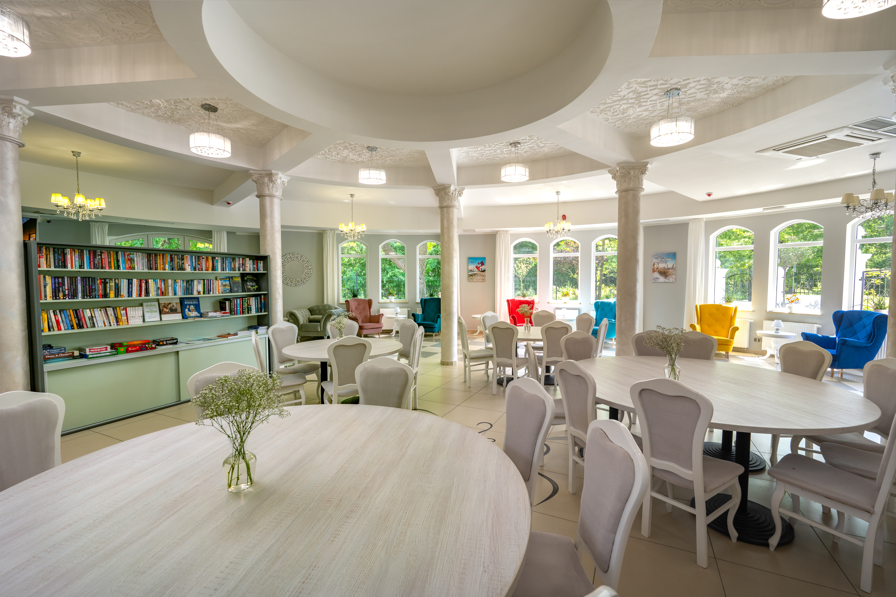 Heller Gemeinschaftsraum mit Bibliothek, Tischen und Sesseln