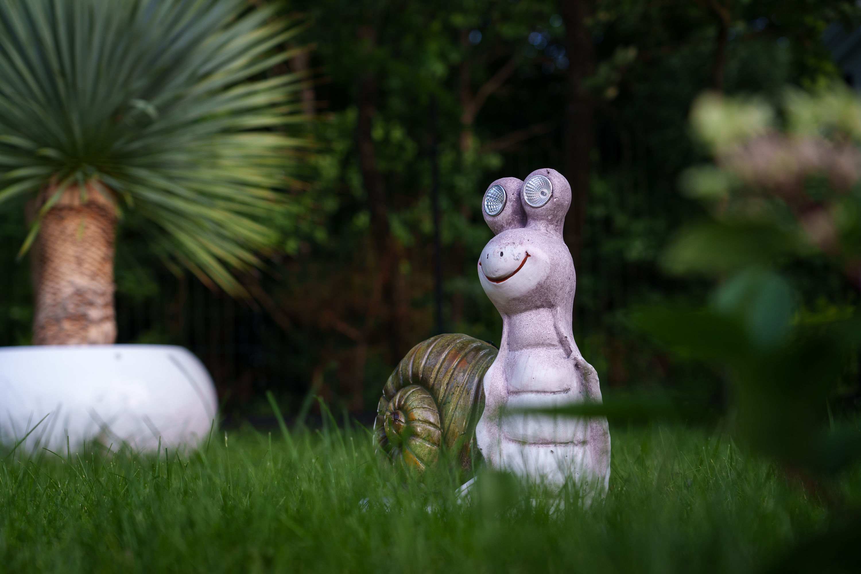 Dekorative Gartenleuchte in Schneckenform im Grünen