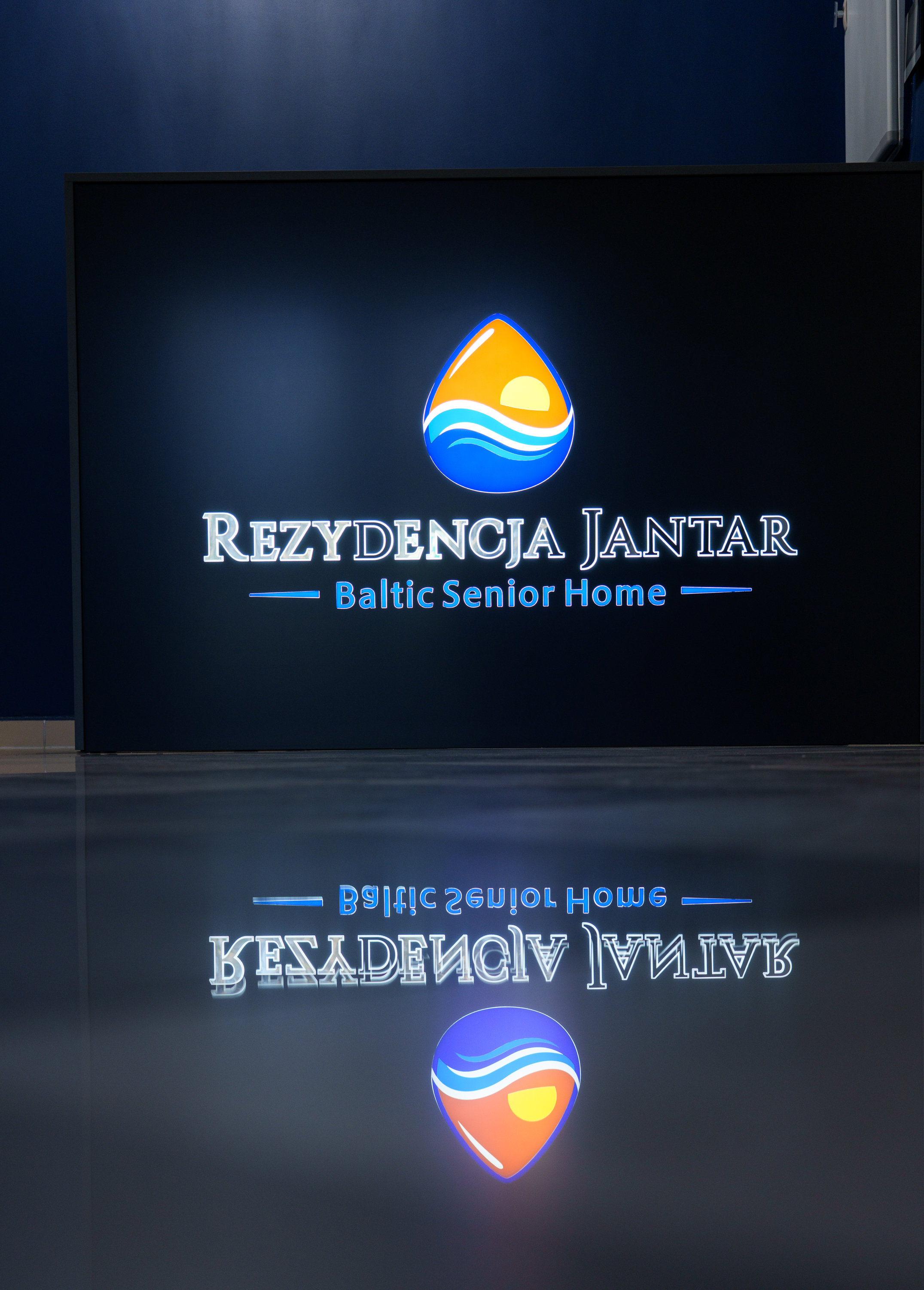 Podświetlane logo Rezydencji Jantar przy recepcji