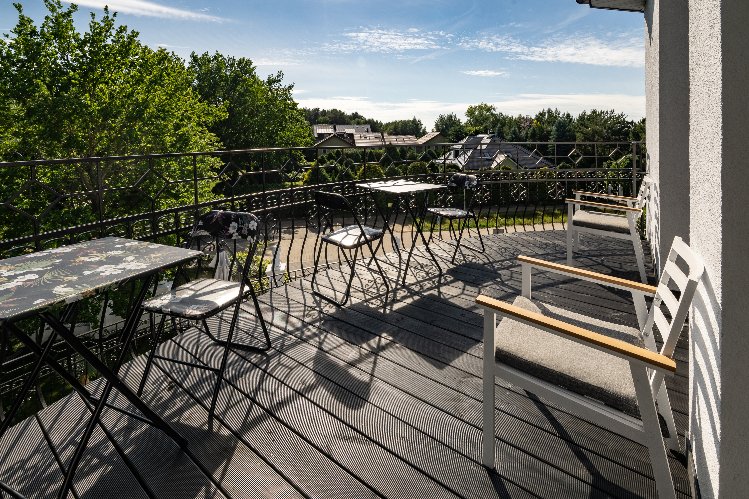 Obere Terrasse mit Tischen und Blick ins grüne Umfeld